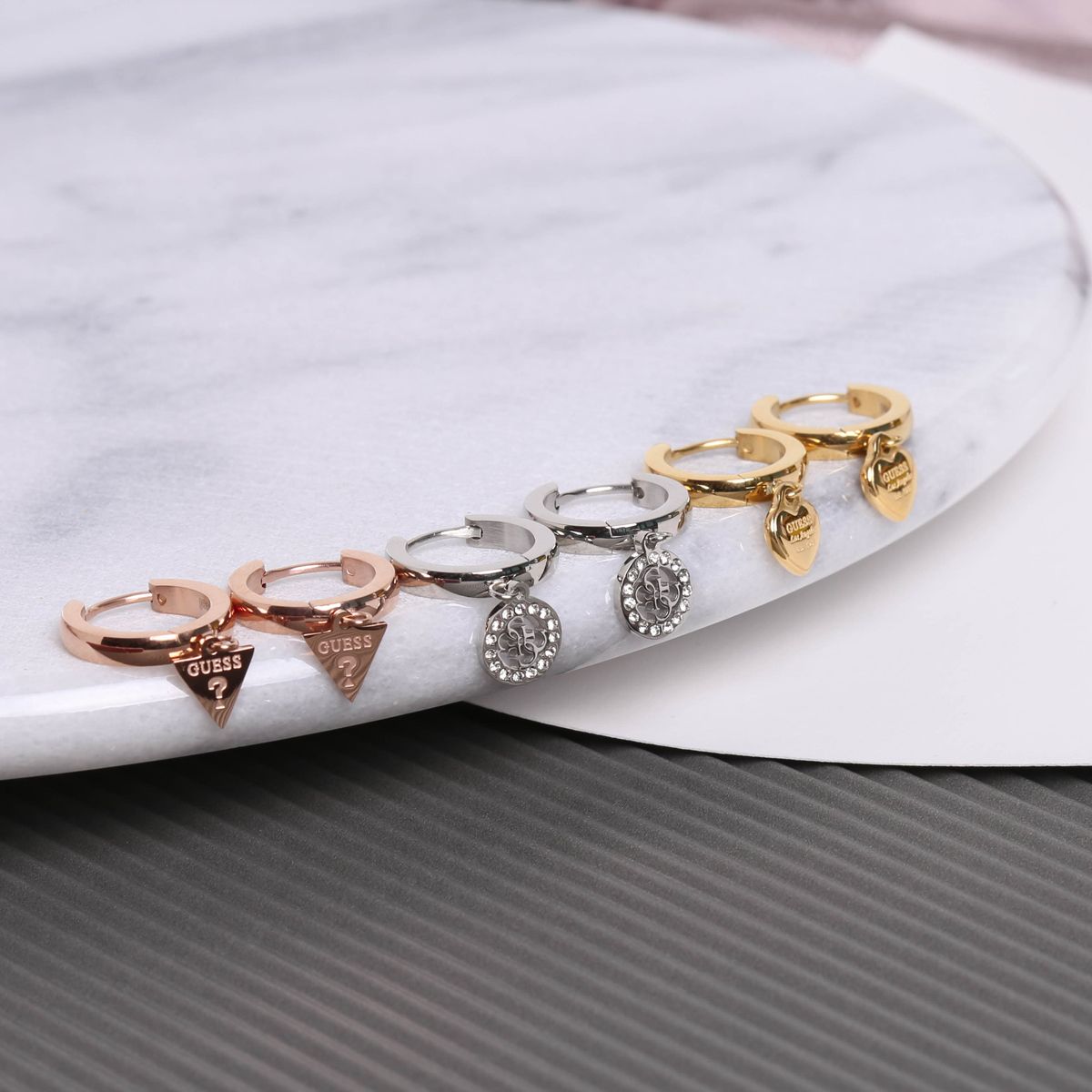 Guess stalen roséplated oorringen met hanger triangle voor dames