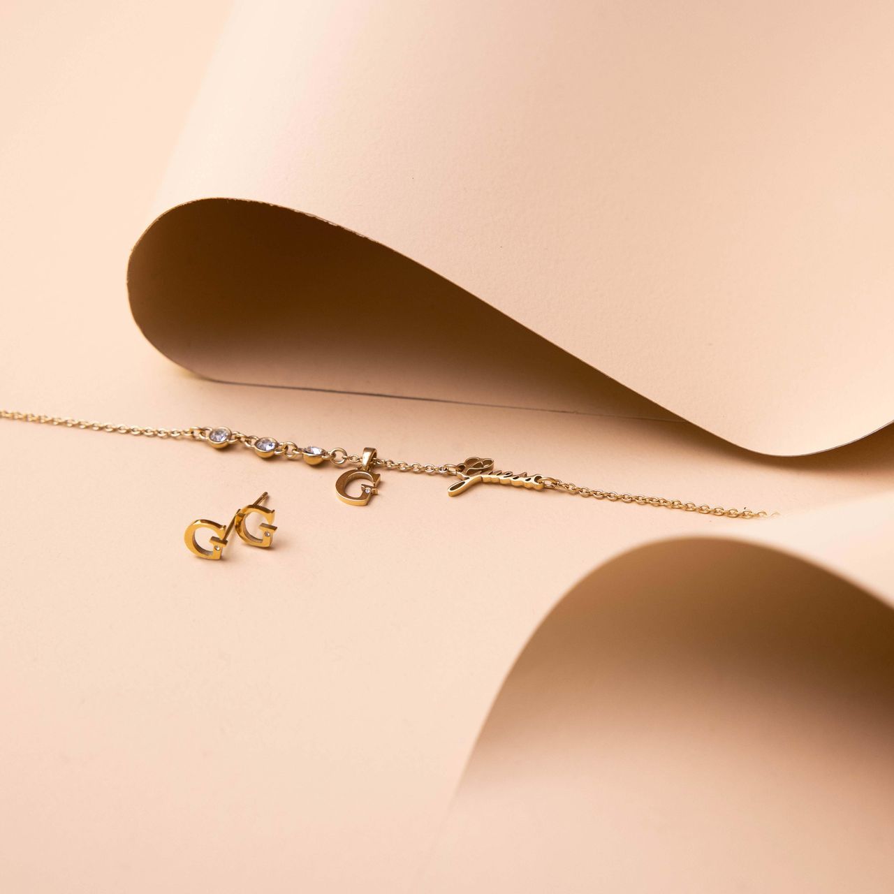 Guess stainless steel goldplated fantasiearmband met letterhanger met kristal voor dames