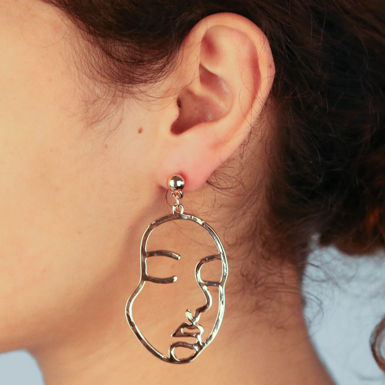 Goudkleurige byoux oorbellen gezicht