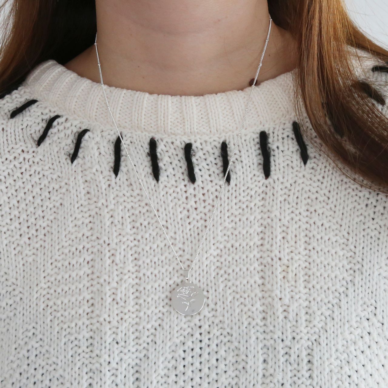Zilverkleurige byoux ketting met munt roos