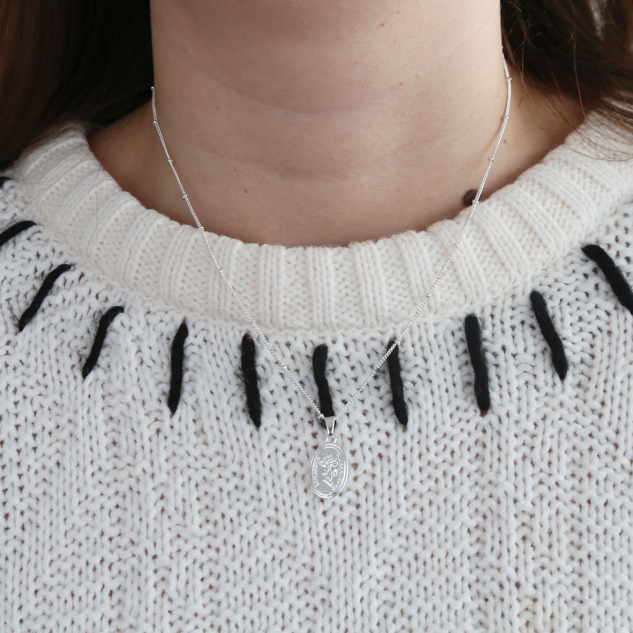 Zilverkleurige byoux keting met ovale munt