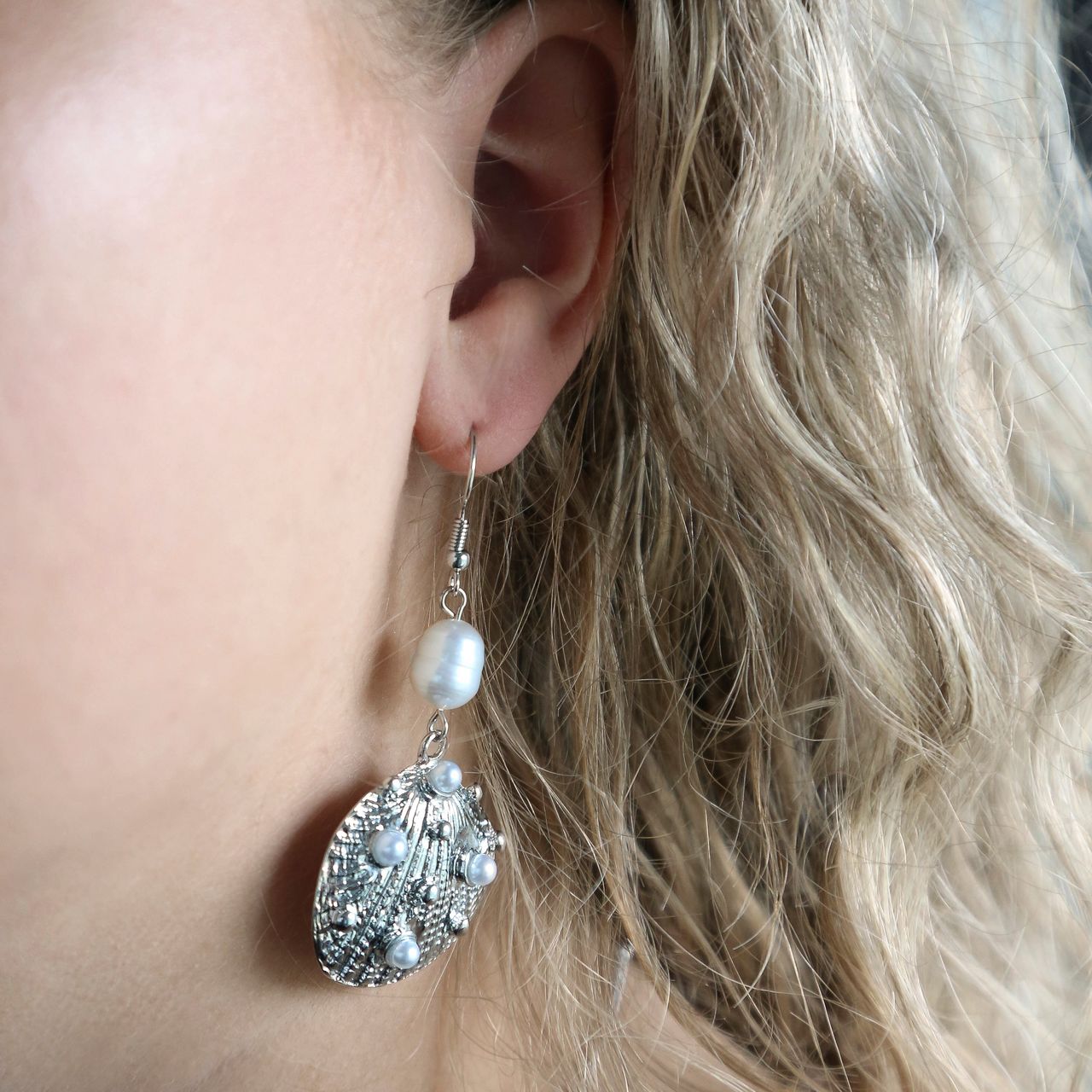 Zilverkleurig bijoux oorbellen met schelp en parel