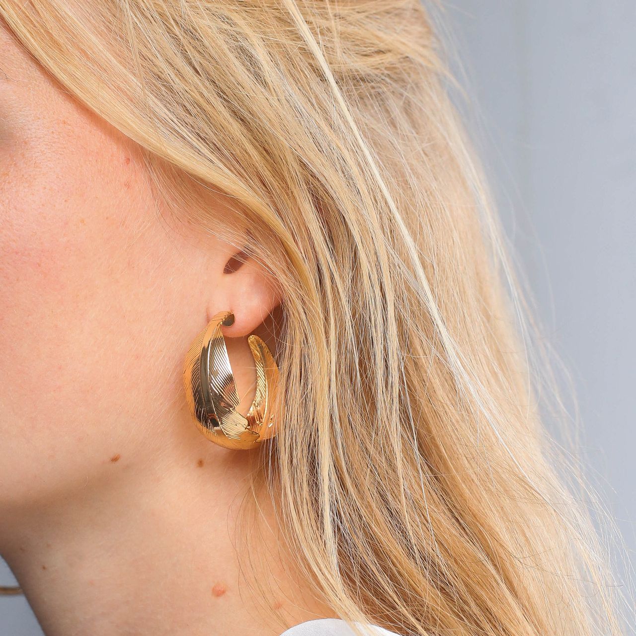 Goudkleurige bijoux oorringen veer