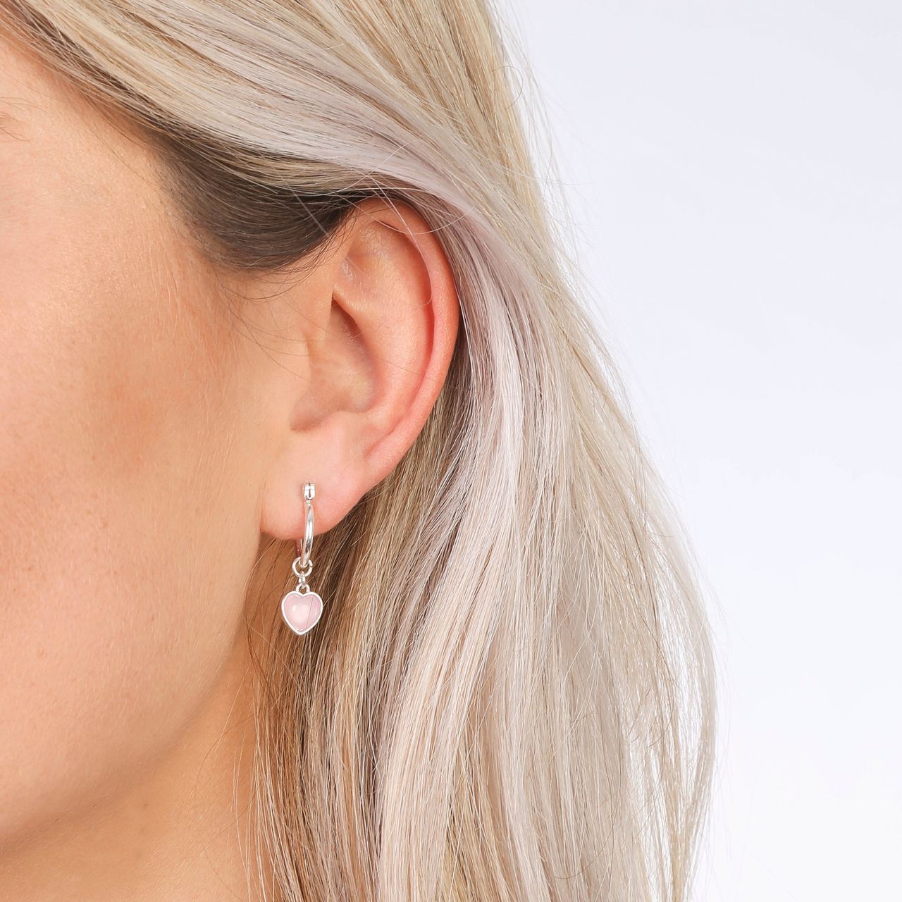 Zilverkleurige byoux oorbellen met roze hartjes