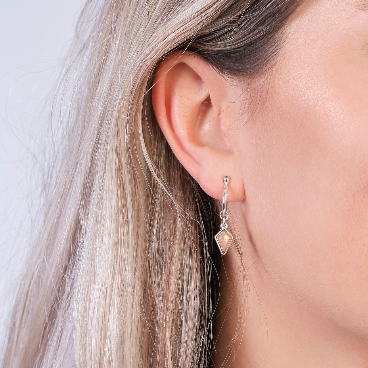 Zilverkleurige byoux oorbellen met oranje steen