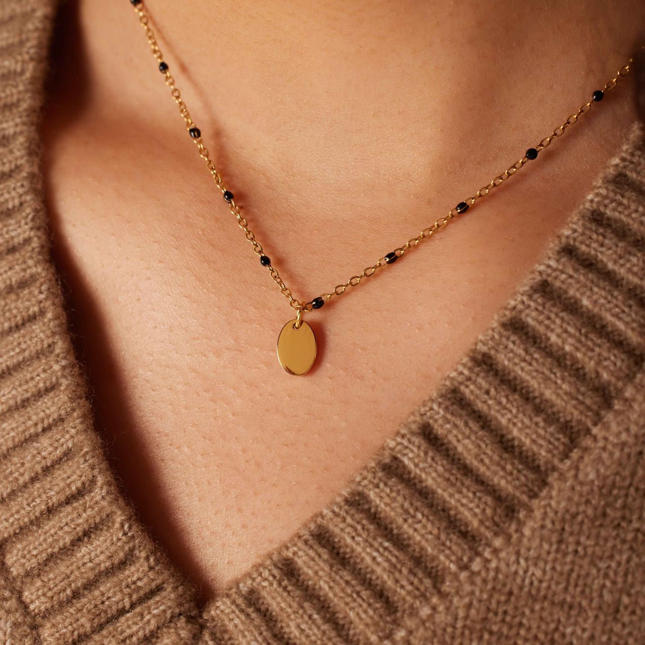 Stainless steel goldplated ketting met zwarte emaille en een ovale graveer hanger voor dames