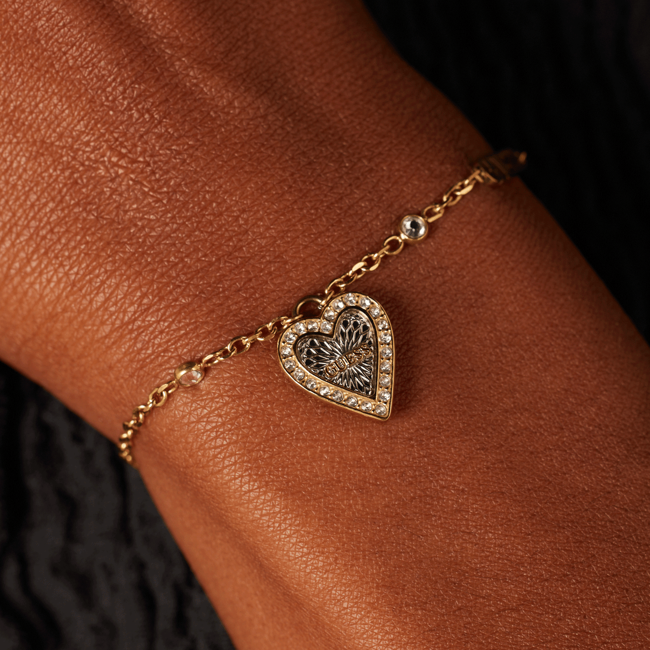 Guess stainless steel goldplated fantasiearmband met hanger hart met kristal voor dames