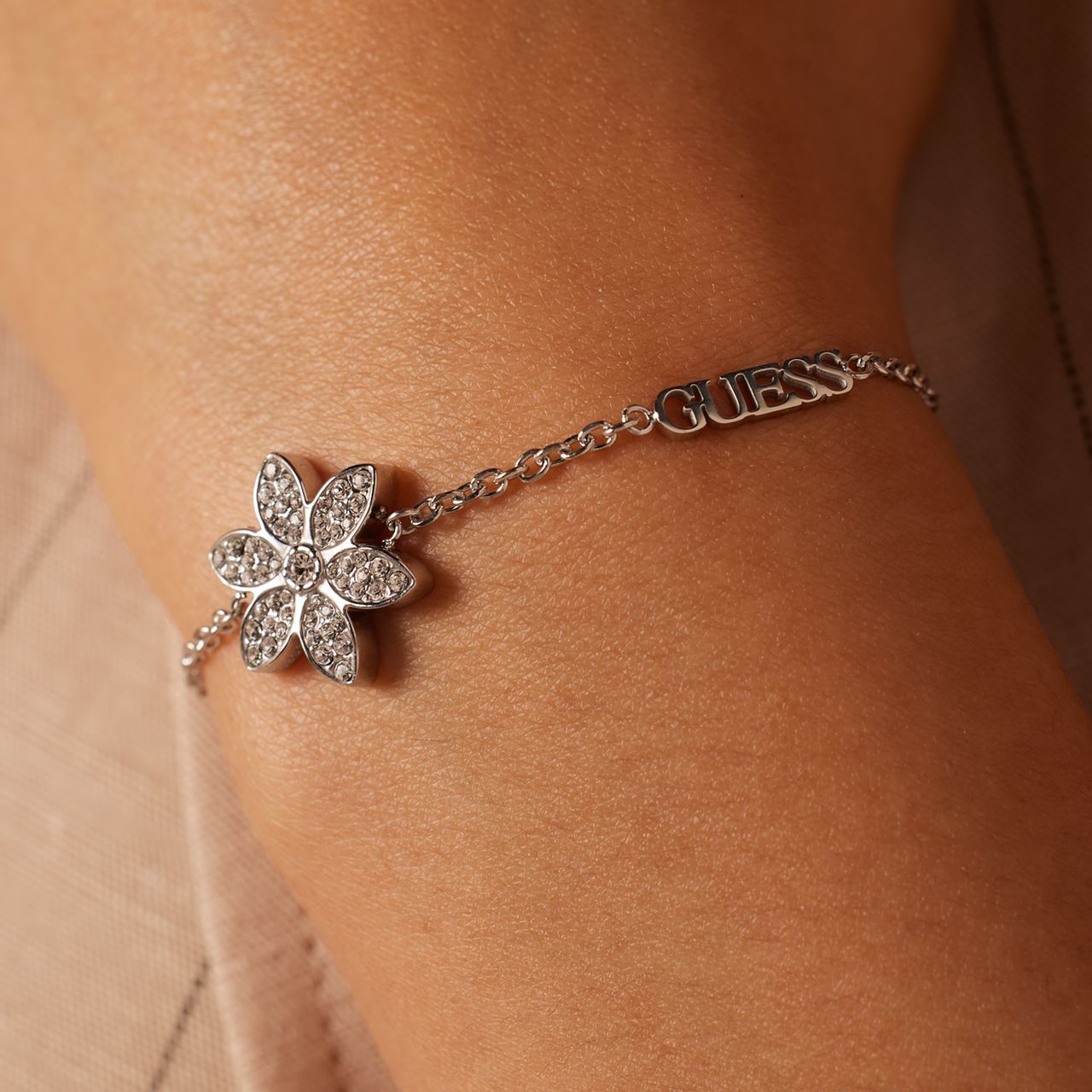 Guess stainless steel goldplated fantasiearmband met hanger bloem met zirkonia voor dames