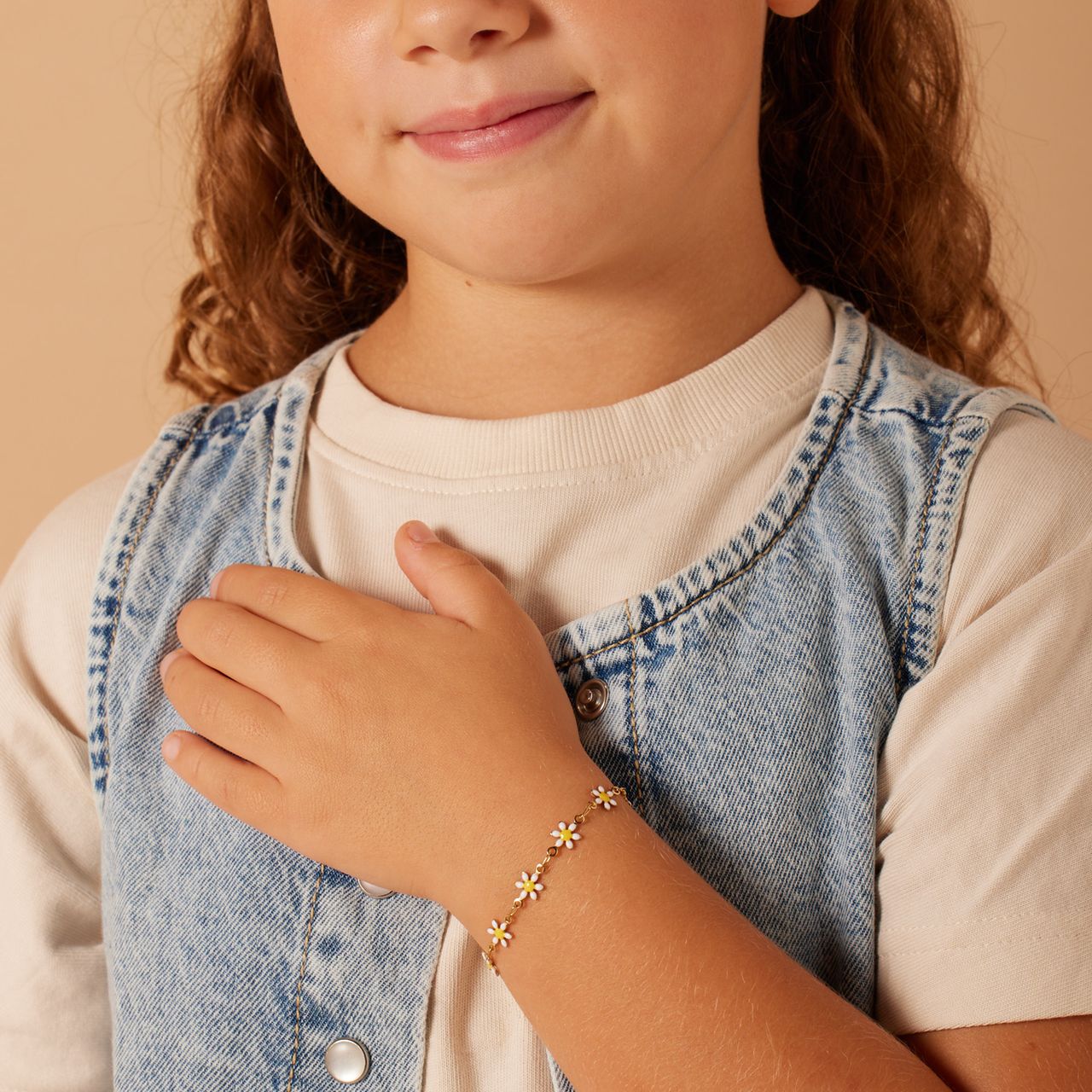 Stählernes, goldfarbenes Kinderarmband mit weißen Gänseblümchen