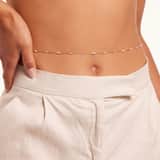 Goldfarbene Bijoux-Bodychain mit Perlen