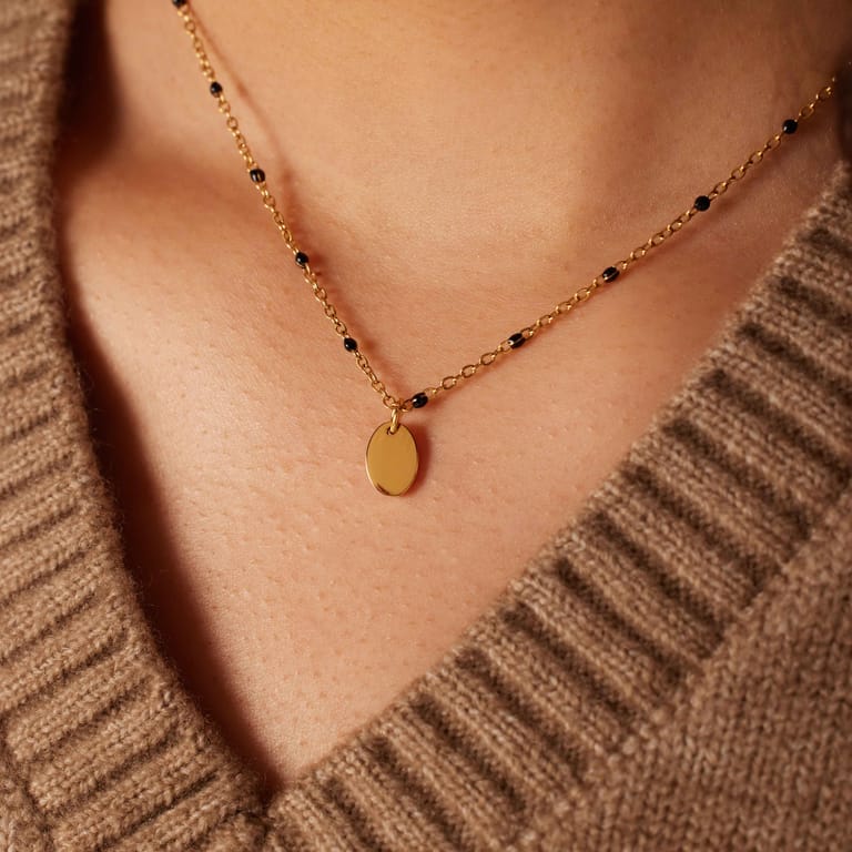 Stalen goldplated ketting met zwarte emaille en een ovale graveer hanger voor dames